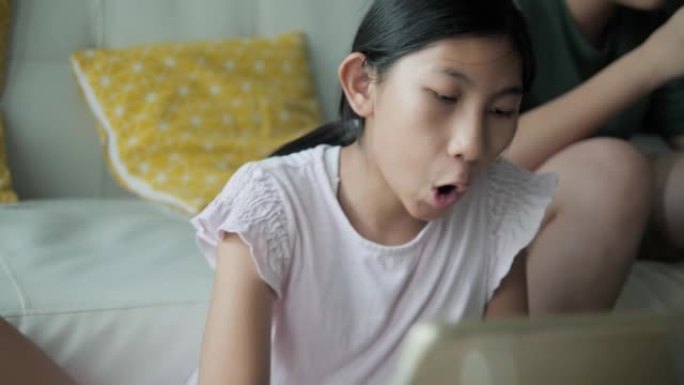 亚洲女孩用数字笔和平板电脑在一起在家玩手机游戏的哥哥附近画画，生活方式概念。