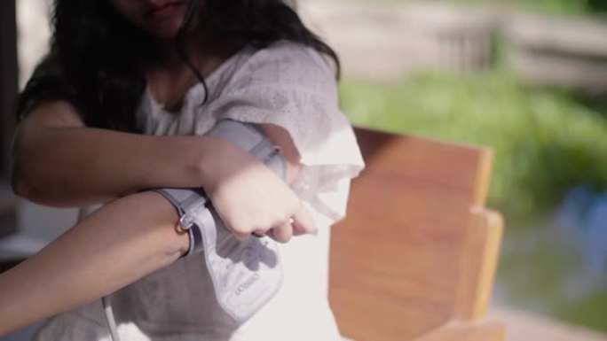 年轻的亚洲妇女在家检查血压。