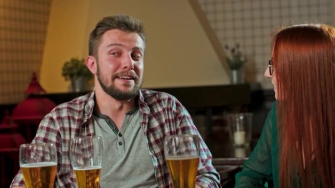 朋友在酒吧一起度过美好时光时会笑，喝啤酒和鸡尾酒