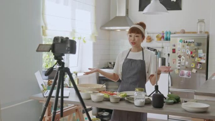 日本女性视频记录器在家里举行的虚拟烹饪课活动中向所有人致意