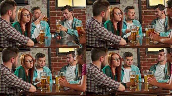 年轻快乐的一群朋友男人和女人在酒吧享受放松夜派对活动庆祝节日。下班后喝啤酒坐在一起聊得很开心