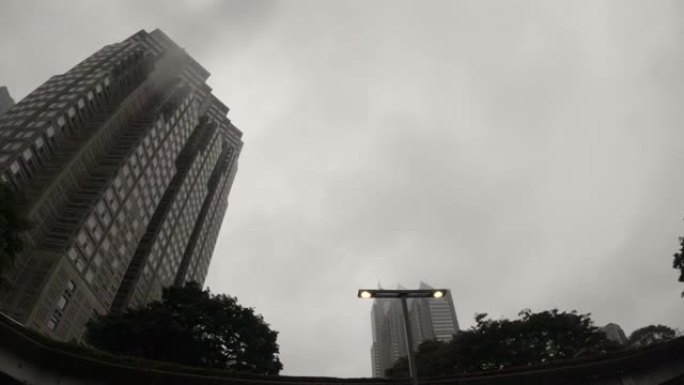 在雨天开车，仰望摩天大楼。