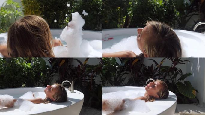 年轻女子在异国情调的户外浴缸中放松。在豪华度假村水疗中心洗澡的女人。