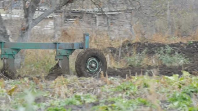 一辆蓝色拖拉机在深秋犁黑土。冬季地面准备