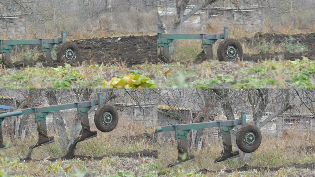 一辆蓝色拖拉机在深秋犁黑土。冬季地面准备