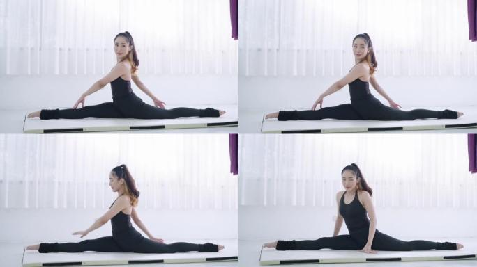 亚洲年轻女子穿着运动训练服独自伸展身体，在练习瑜伽作为新的正常生活之前诱导身体柔韧性，为了安全起见呆