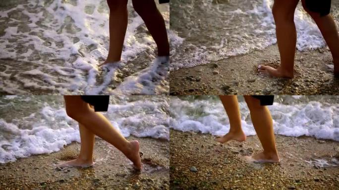 女性的腿沿着海边行走。一个女孩走路