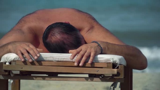 海滩度假男子躺在离子海滩床休息室日光浴