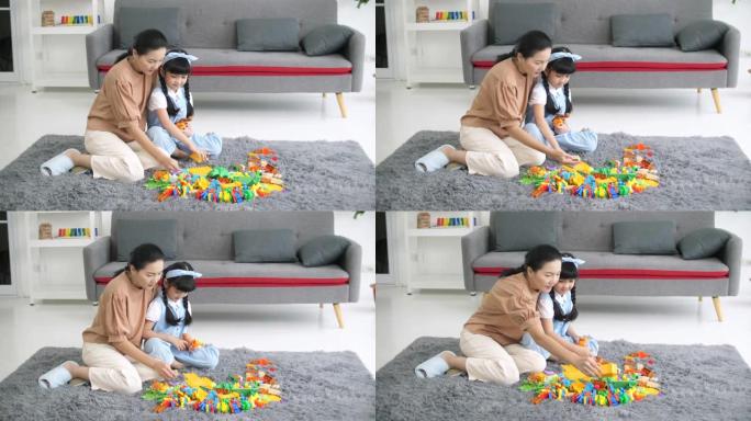 亚洲母亲和孩子一起在地板上玩积木玩具