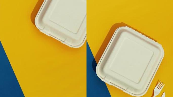 彩色桌子上的午餐盒和餐具。平放顶视图送餐概念