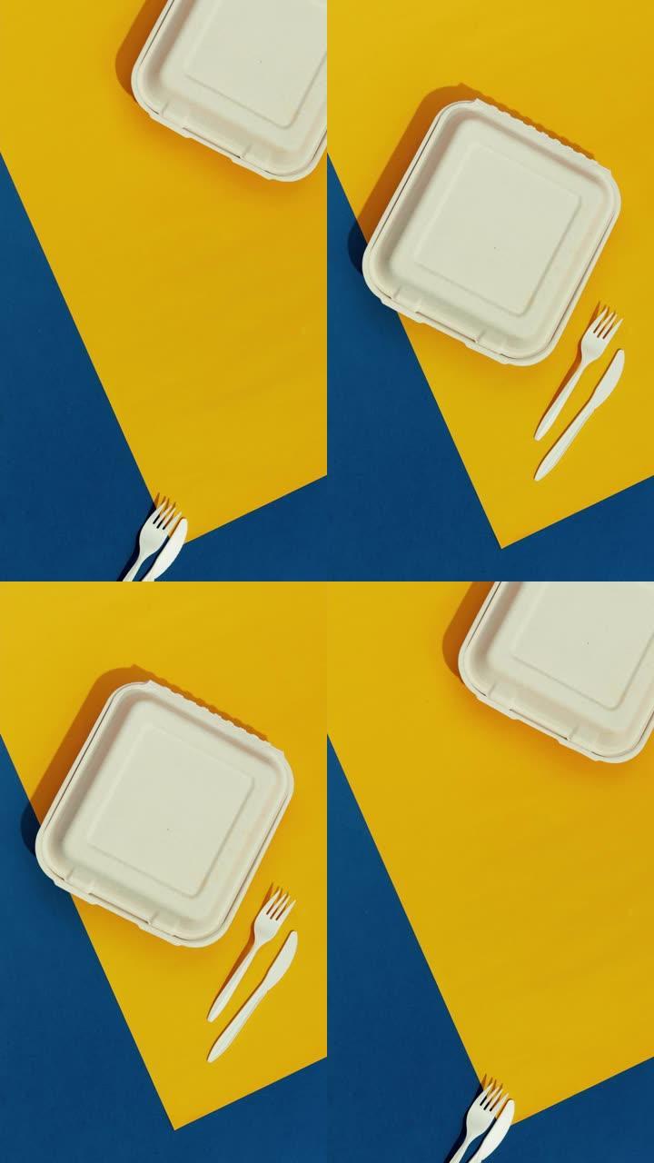 彩色桌子上的午餐盒和餐具。平放顶视图送餐概念