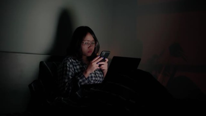 女人晚上在卧室使用智能手机