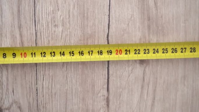 用黄色卷尺测量。用手将卷尺从卷尺中拉出并测量长度。4k素材。