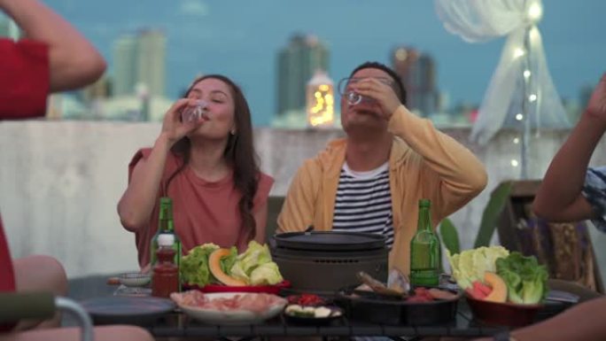 多元化的亚洲朋友喜欢在屋顶庆祝晚宴