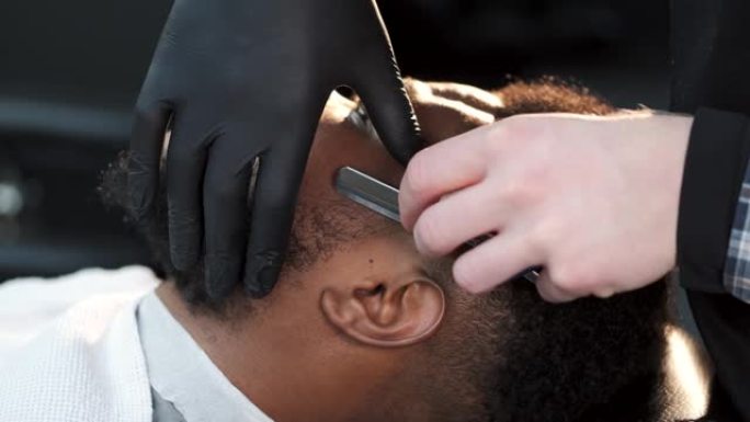 理发师用古典剃刀刮他的客户