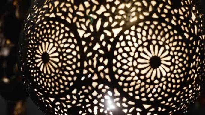 点燃的摩洛哥阿拉伯黄铜灯，带有复杂的花卉图案。摩洛哥和阿拉伯灯设计的概念。