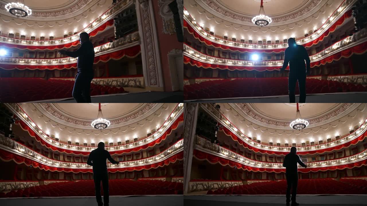 古典剧院大厅背景上的人。演出前排练。演员正在空荡荡的礼堂里讲话。从场景中观看。