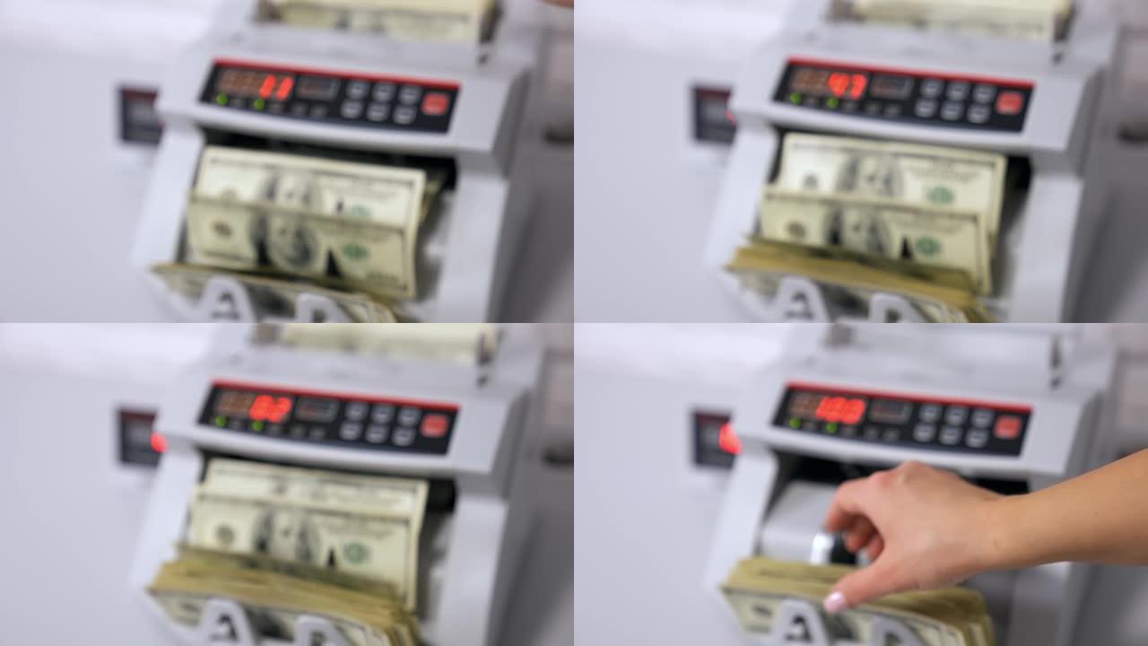 数数美元钞票。点钞机与100美元的钞票。女性的手握着一包美国国家纸币。金融概念。特写。背景模糊。