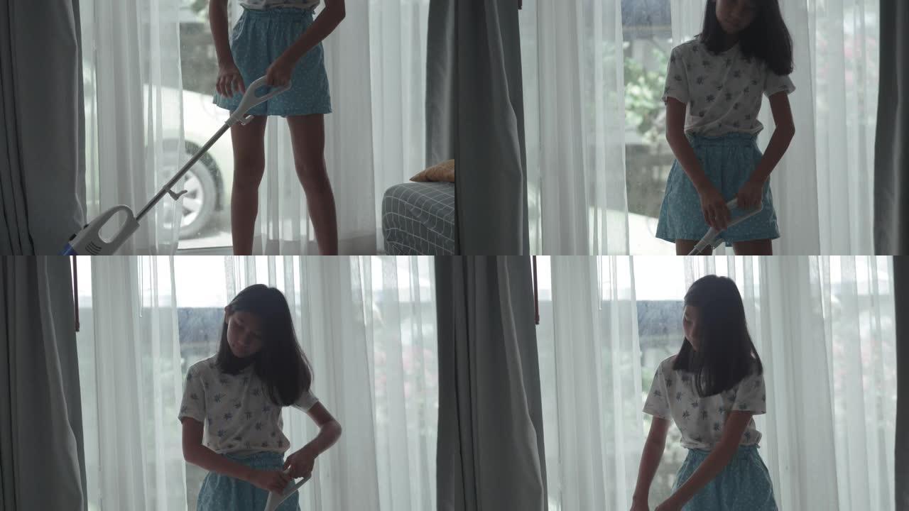 亚洲女孩在家使用吸尘器清洁窗户附近，生活方式理念。