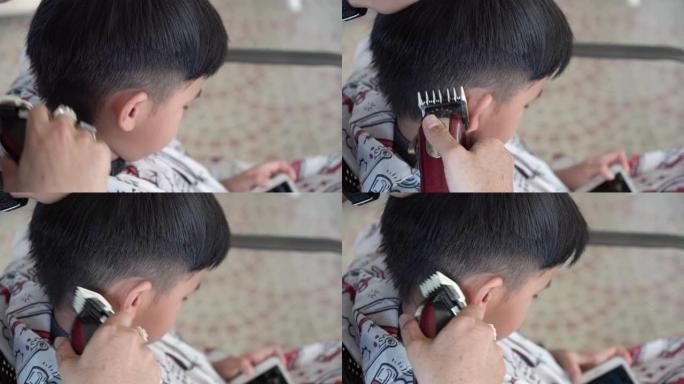 在新型冠状病毒肺炎电晕病毒的情况下在家剪儿子的头发。