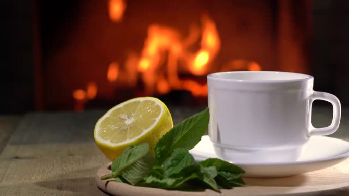 船上舒适的壁炉、茶壶和一杯柠檬和薄荷茶。