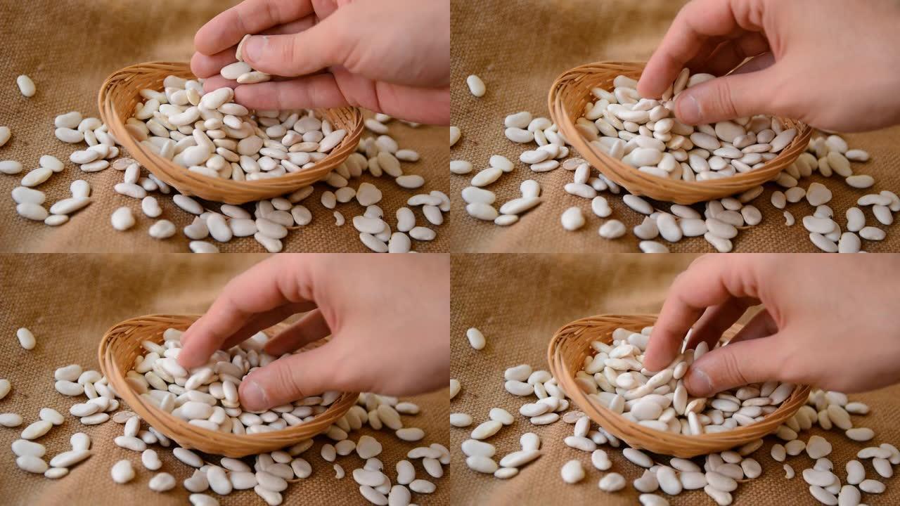碗中的白豆和男人的手检查质量