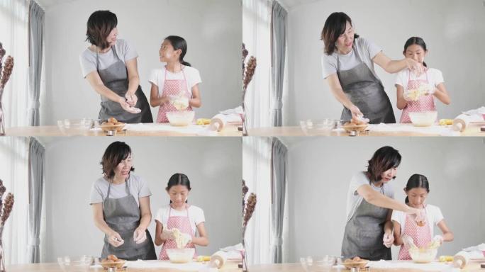 快乐的亚洲女孩在家帮助母亲一起制作面包或比萨饼的面团，生活方式的概念。
