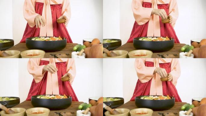 穿着韩服韩国传统服装的亚洲女性正在烹饪泡菜