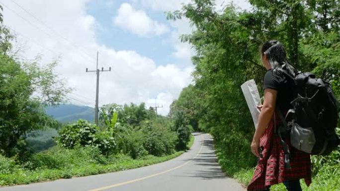 在泰国迷人的风景自然中，暑假旅行期间，旅行妇女在路边背包搭便车。旅行和搭便车的概念。