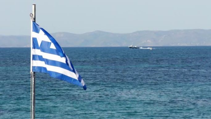 挥舞着希腊国旗，背景是大海