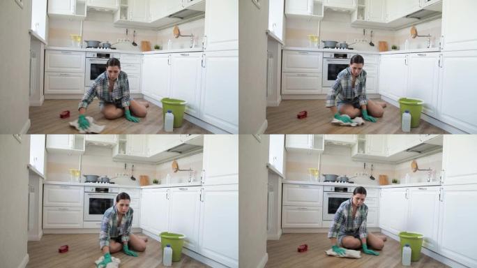 一个穿着牛仔短裤和衬衫的女孩在家洗地板。