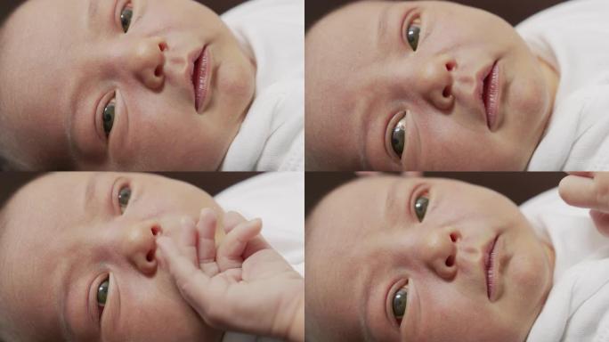 特写初生婴儿醒来睁开眼睛的脸。一个刚出生的婴儿在梦中做鬼脸。出生的最初几分钟。