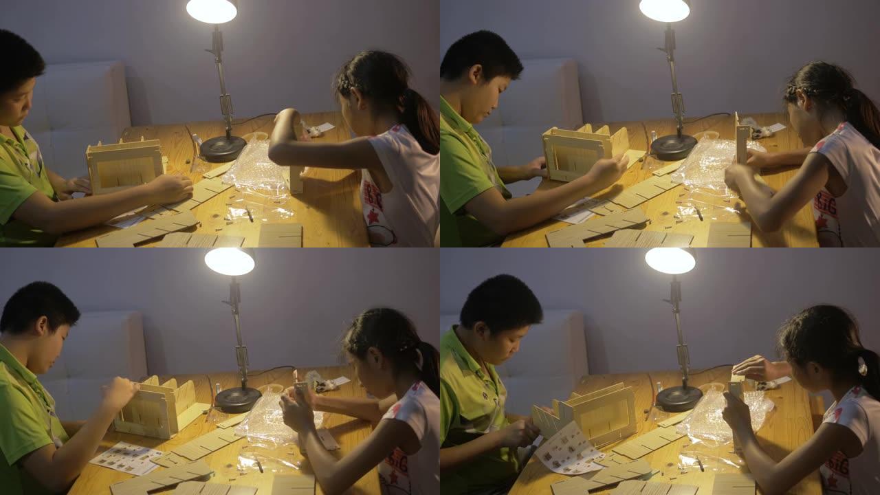 快乐的亚洲男孩和女孩在晚上在家，生活方式和DIY概念中自己拧木架子。