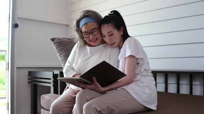 微笑的母女俩坐在沙发上看书