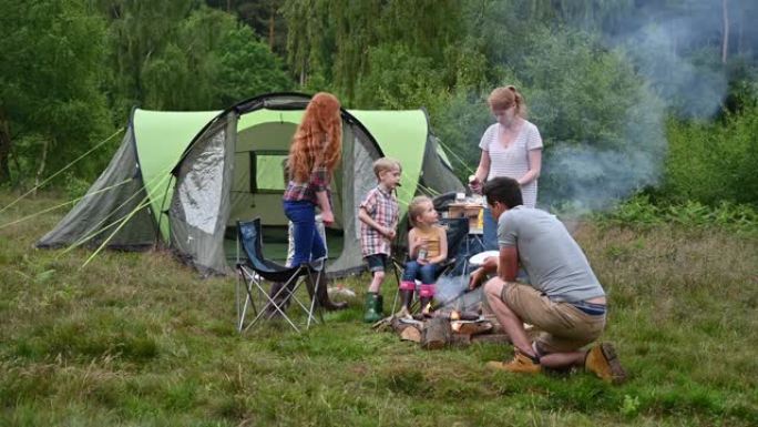 家庭在周末野营旅行中享受户外野餐