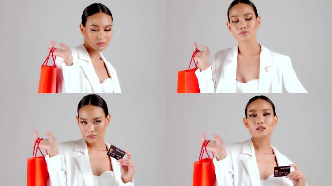 美丽的亚洲现代外观女商人拿着红色购物袋和信用卡