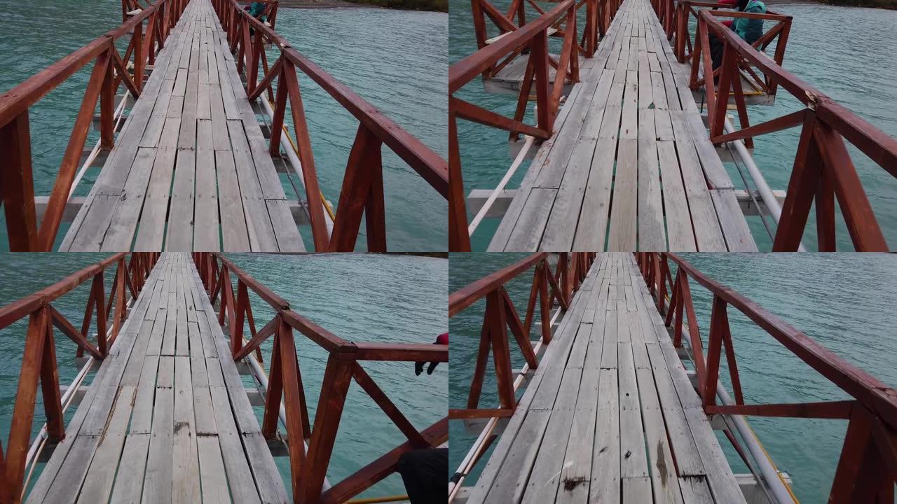 一个男人走过一座桥，一座横跨湖上的桥，一座横跨巴塔哥尼亚湖上的桥