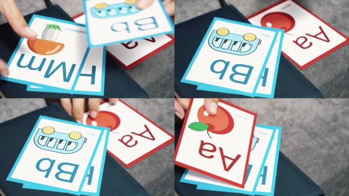 女性双手的特写镜头，用带有字母和图片的彩色卡片学习字母表。学前教育或学习英语。