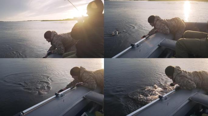 朋友钓鱼。两名业余垂钓者从船上钓鱼并与奖杯鱼搏斗