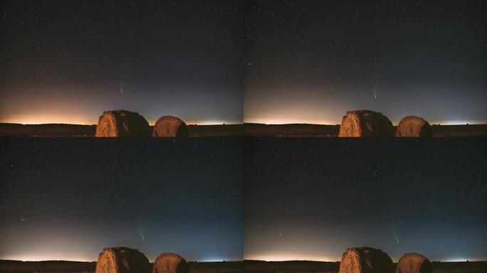 彗星Neowise C/2020 F3在夏季农田干草堆上方的夜星天空。收获后，夜星在乡村景观之上，干