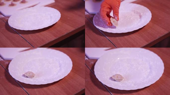 用面粉将手工制作的生饺子放在盘子上