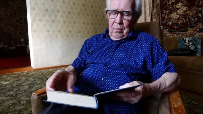 一位戴着眼镜的老人坐着看书。