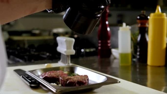 餐厅厨房里主厨腌制和胡椒牛排的特写镜头。