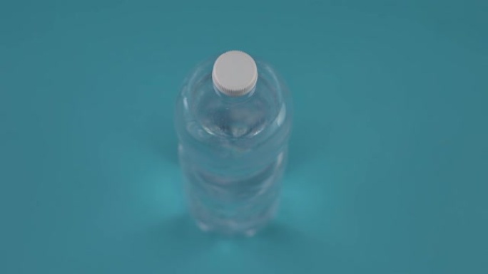 淡蓝色背景上带水的瓶子上方运动