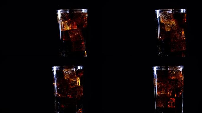 可乐配冰块。旋转玻璃的侧视图，其中冷碳酸棕色甜饮料倒在黑色背景上，与自由复制空间隔离。慢动作200 
