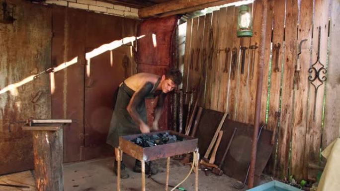 一个男铁匠将空气泵入锻造炉。