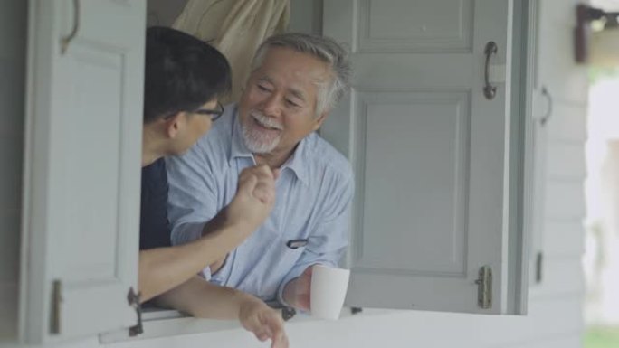 微笑亚洲父亲和大儿子呆在家里一段时间的检疫和社交距离