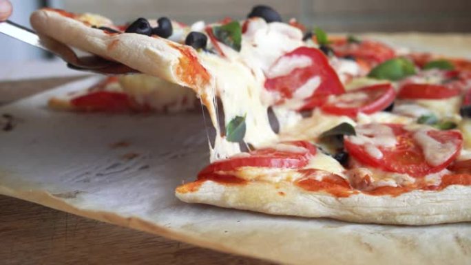 拿一片自制披萨，里面有融化的奶酪和西红柿