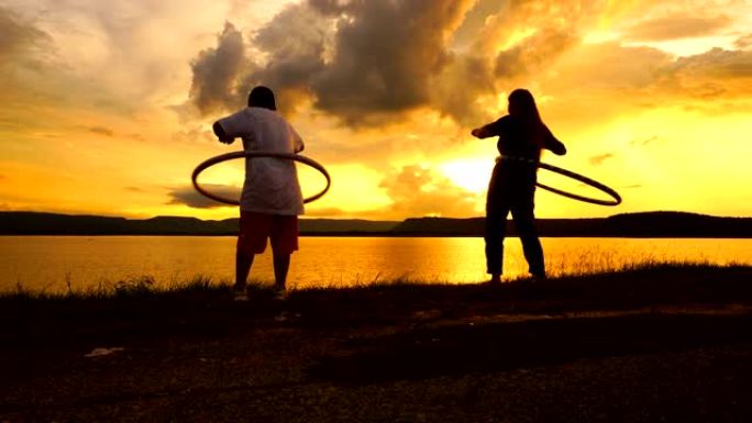 母亲和儿子在日落湖玩呼啦圈