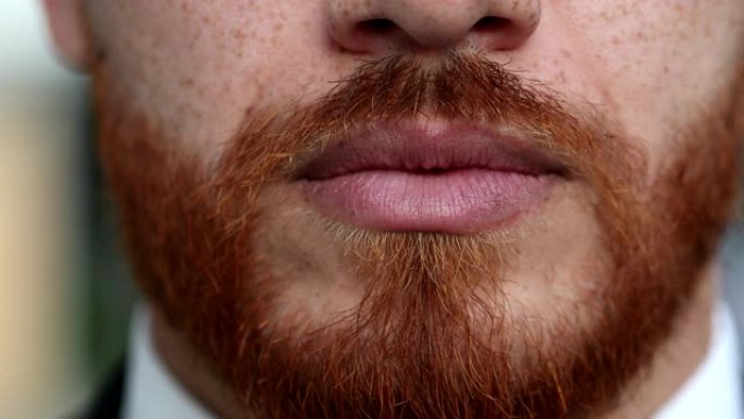 严肃的红发男人嘴唇和嘴巴特写，留着红胡子